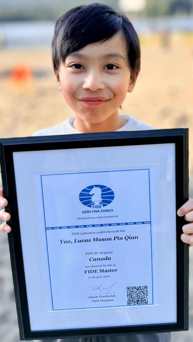 Lucas holding his framed FIDE Master certificate