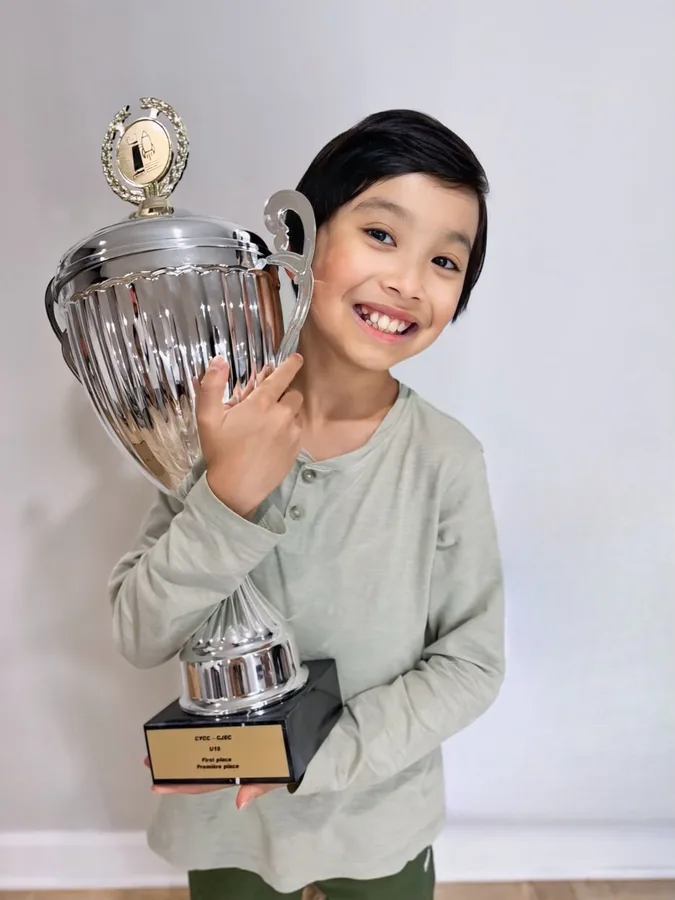 Lucas Yao holding his first-place trophy from the Canadian Youth Chess Championship