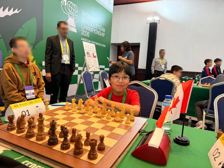 Lucas Yao at the board beneath the World Schools Team Championship banner