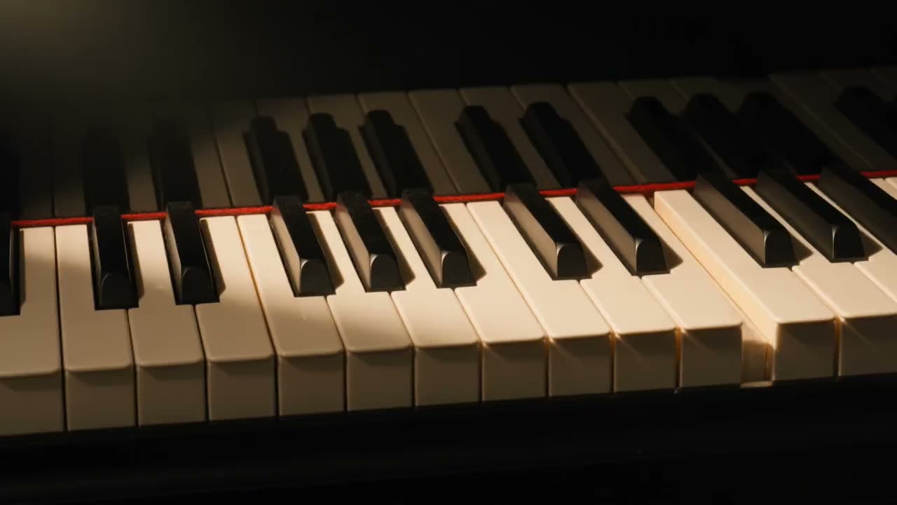 A grand piano keyboard in warm raking light