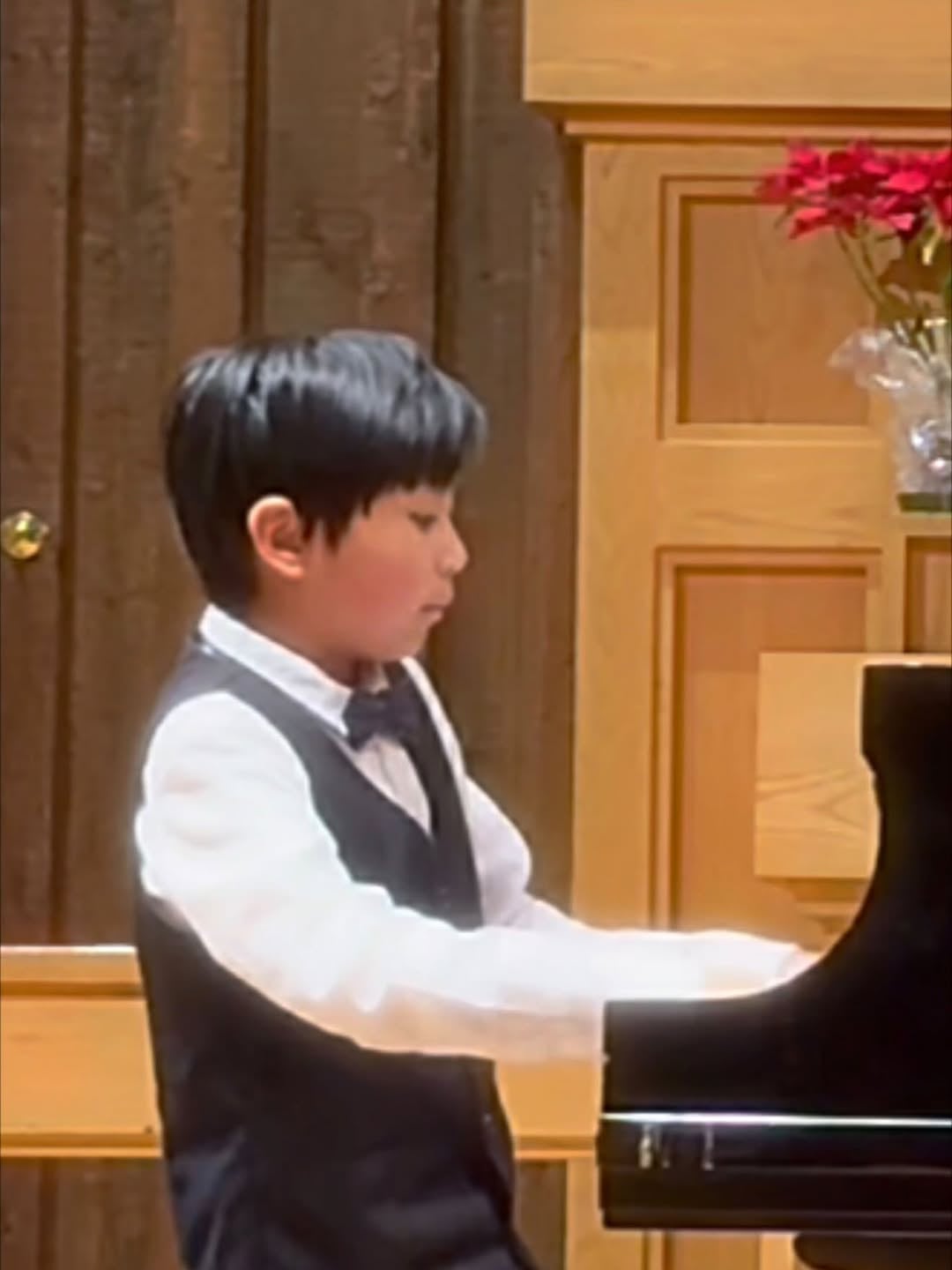 Lucas Yao performing at the grand piano in recital dress